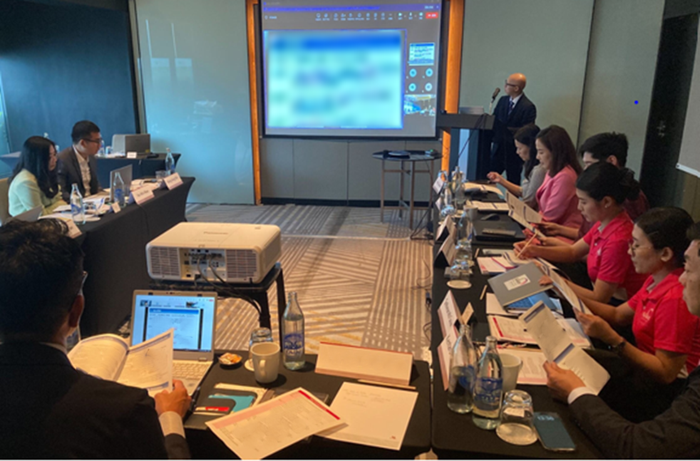 会議室で、当社グローバルビジネスグループのメンバーと、東南アジア5カ国（ベトナム、タイ、ミャンマー、カンボジア、ラオス）のパートナー企業の担当者が着席し、資料を手に討議している様子。